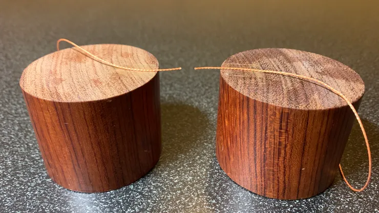 以雙面膠將線的兩端固定在木柱上