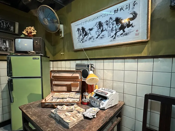 一邊是毒品交易,雖然不見白粉,只有一堆堆美元鈔票,還有舊式佈置的場景