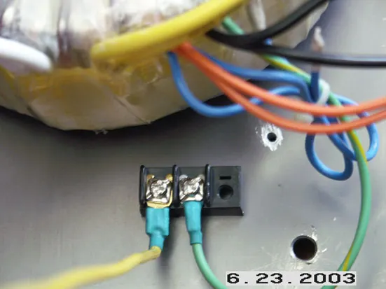 將底板挖兩個洞，安裝端子座，做為地線聯結，右邊綠色線為變壓器之 Screen，左邊黃線連接至濾 波電容 Ground